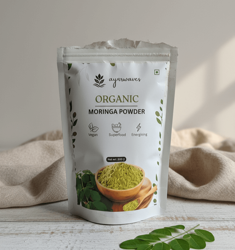 Ayuurvedic Organic Moringa Powder package on a wooden surface with a beige cloth in the background.