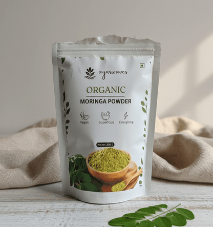 Ayuurvedic Organic Moringa Powder package on a wooden surface with a beige cloth in the background.