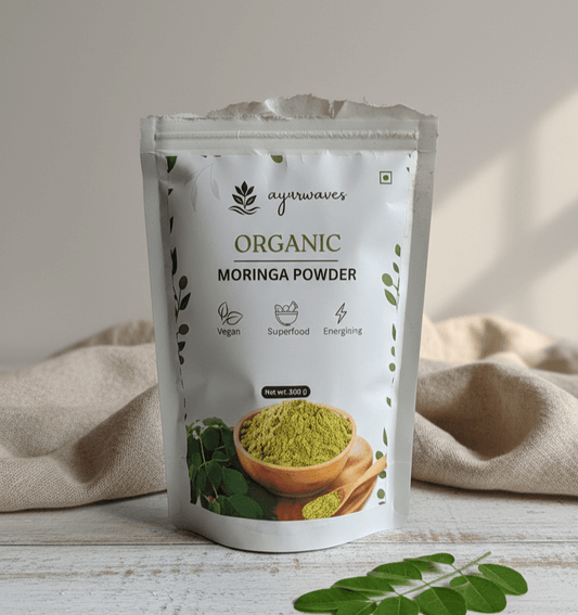 Ayuurvedic Organic Moringa Powder package on a wooden surface with a beige cloth in the background.
